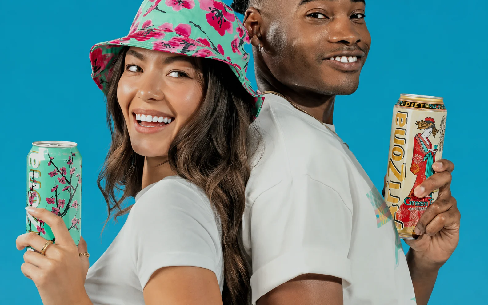 AriZona iced tea cans held by two people