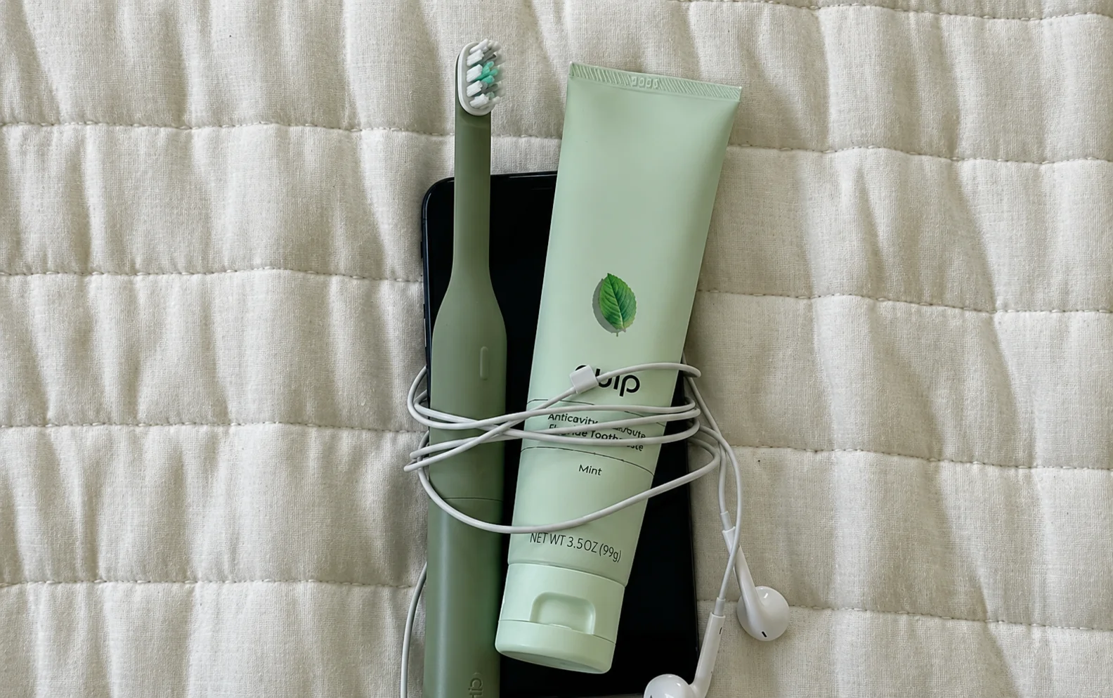 quip electric toothbrush mounted on a tiled wall