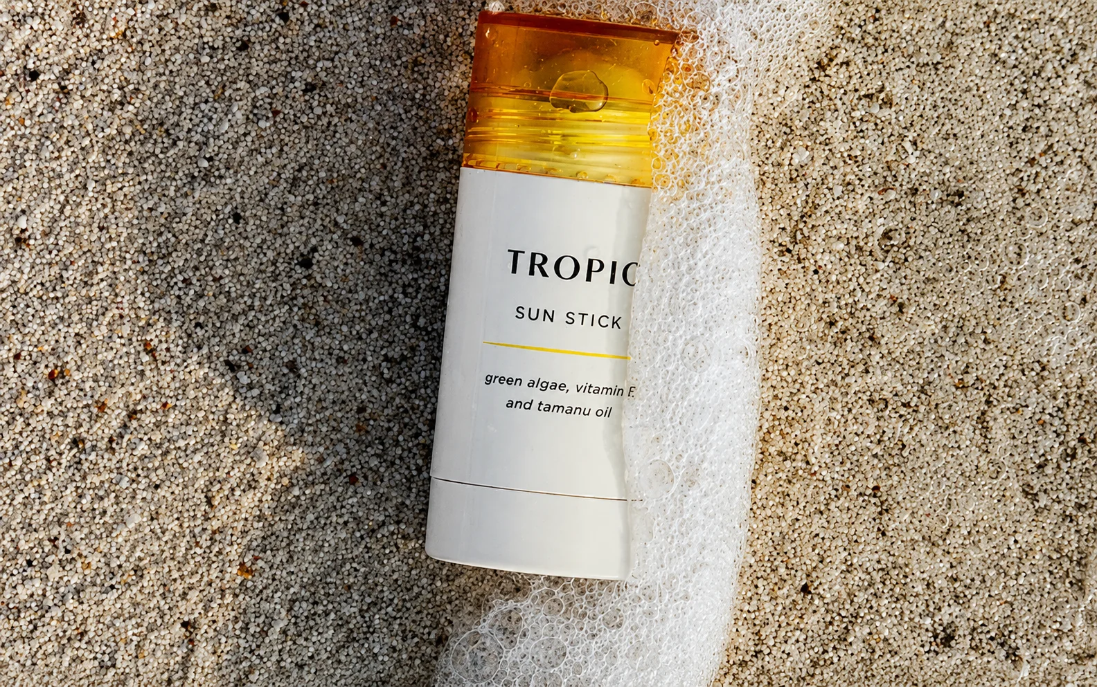 Tropic Skincare bottle on a sunlit stone surface